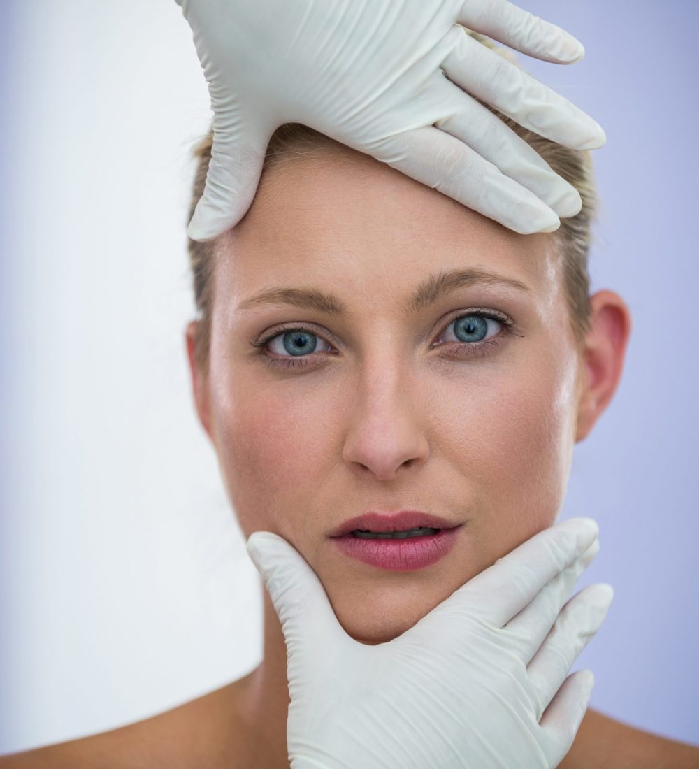 Doctor examining female patients face from cosmetic treatment